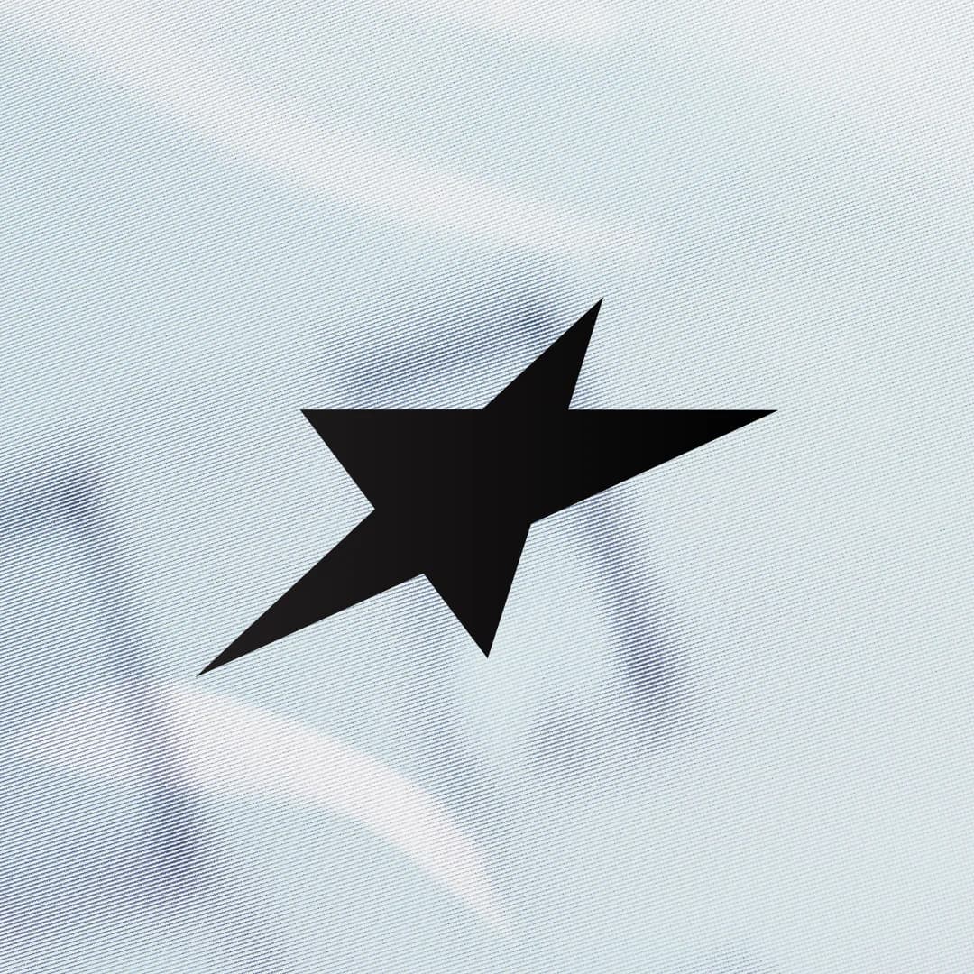 Black angular star mark on a textured white background